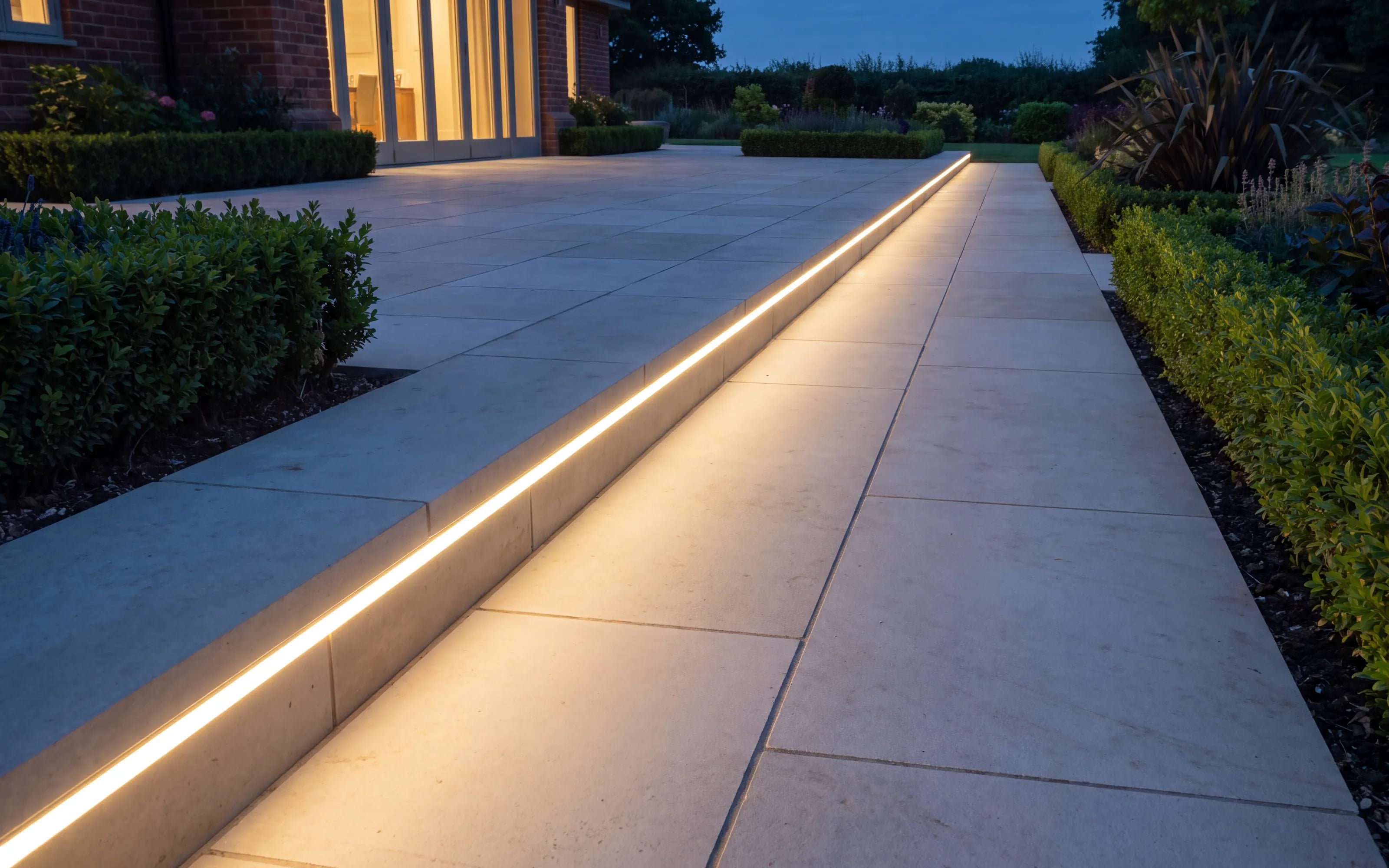 Warm white outdoor LED lighting installed along a stone terrace