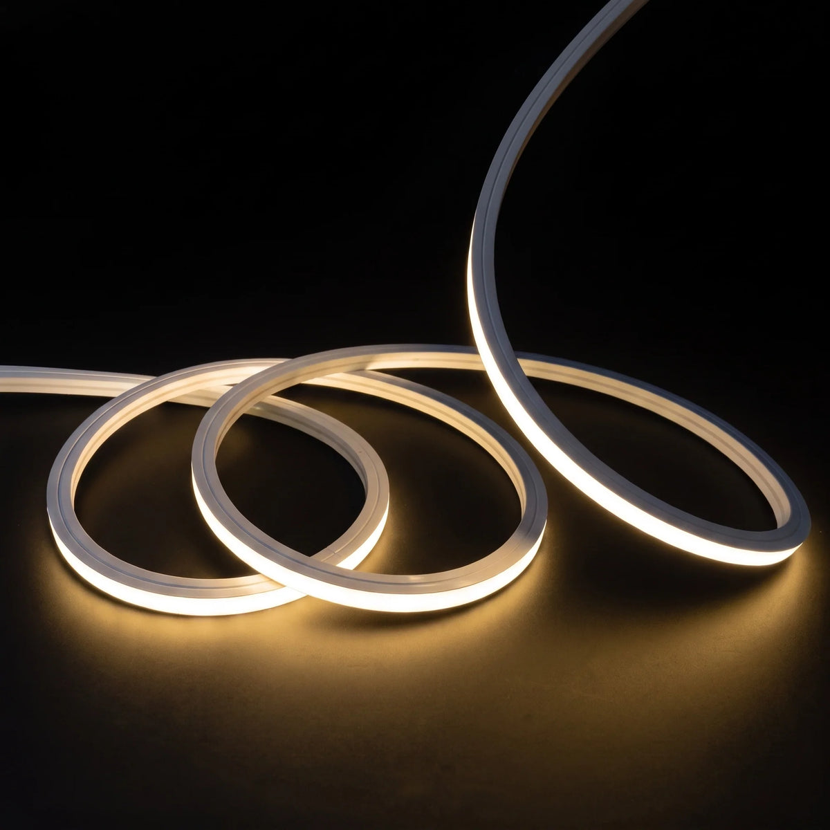 Warm White 2700K LED Neon Flex 15x15mm Top Bend, overlapping offset coils with raised arc and colour glow on a black surface