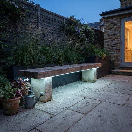 Icy blue-white RGB mixed light recessed underneath an outdoor timber bench