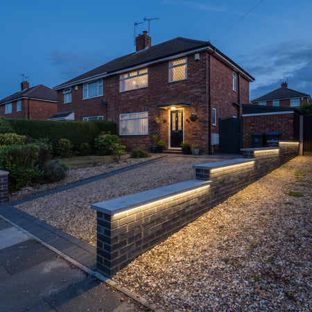 Soft pale-yellow RGB mixed light beneath every stepped driveway wall coping