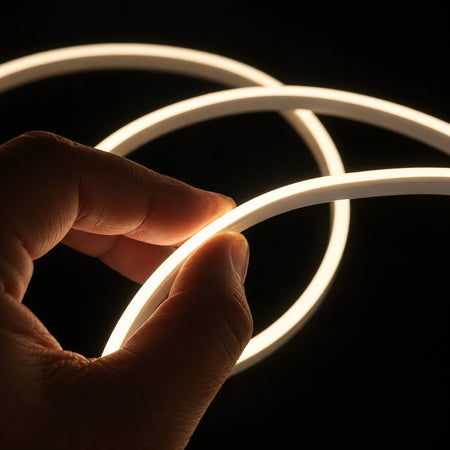 Hand holding illuminated warm-white mini neon flex — product reference