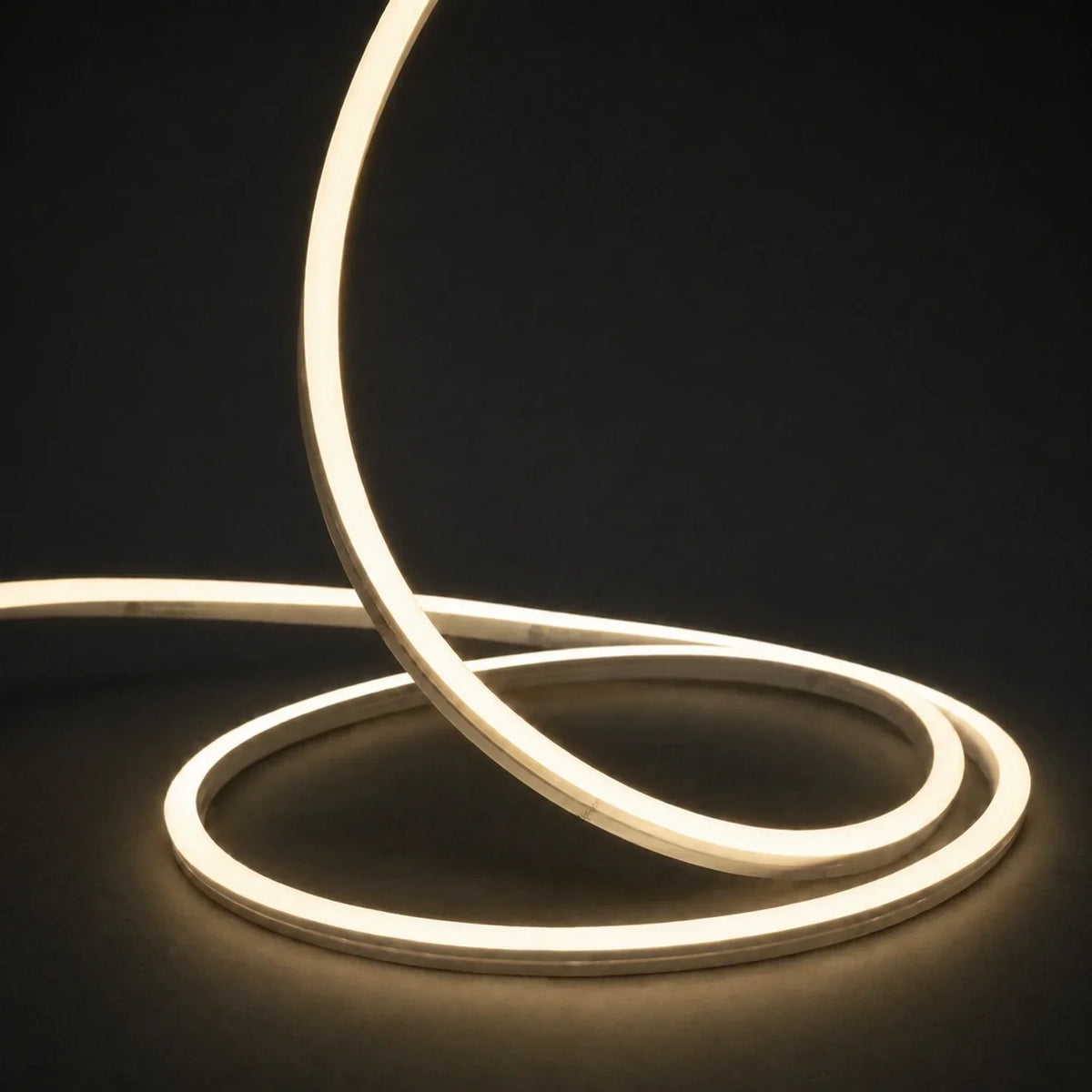 3000K side-bend Neon Flex raised in loops on a dark surface, colour-adjusted product photograph