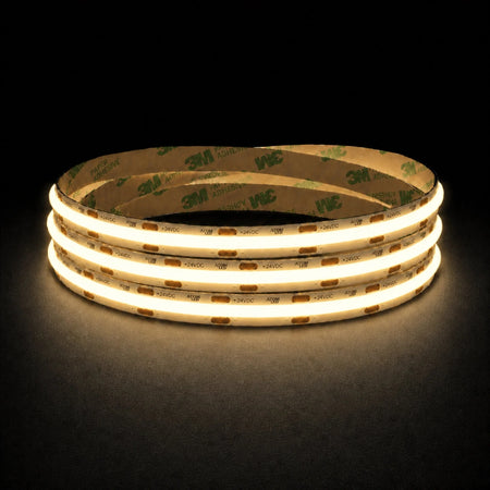 Warm White 2700K 24V 10mm COB LED strip shown illuminated in a coil on a dark background.