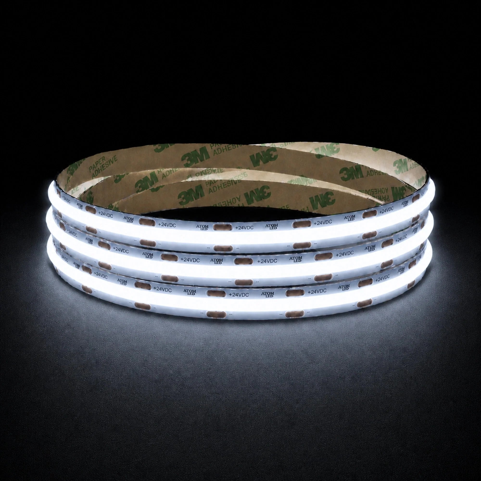 Cool White 6500K 24V 10mm COB LED strip shown illuminated in a coil on a dark background.