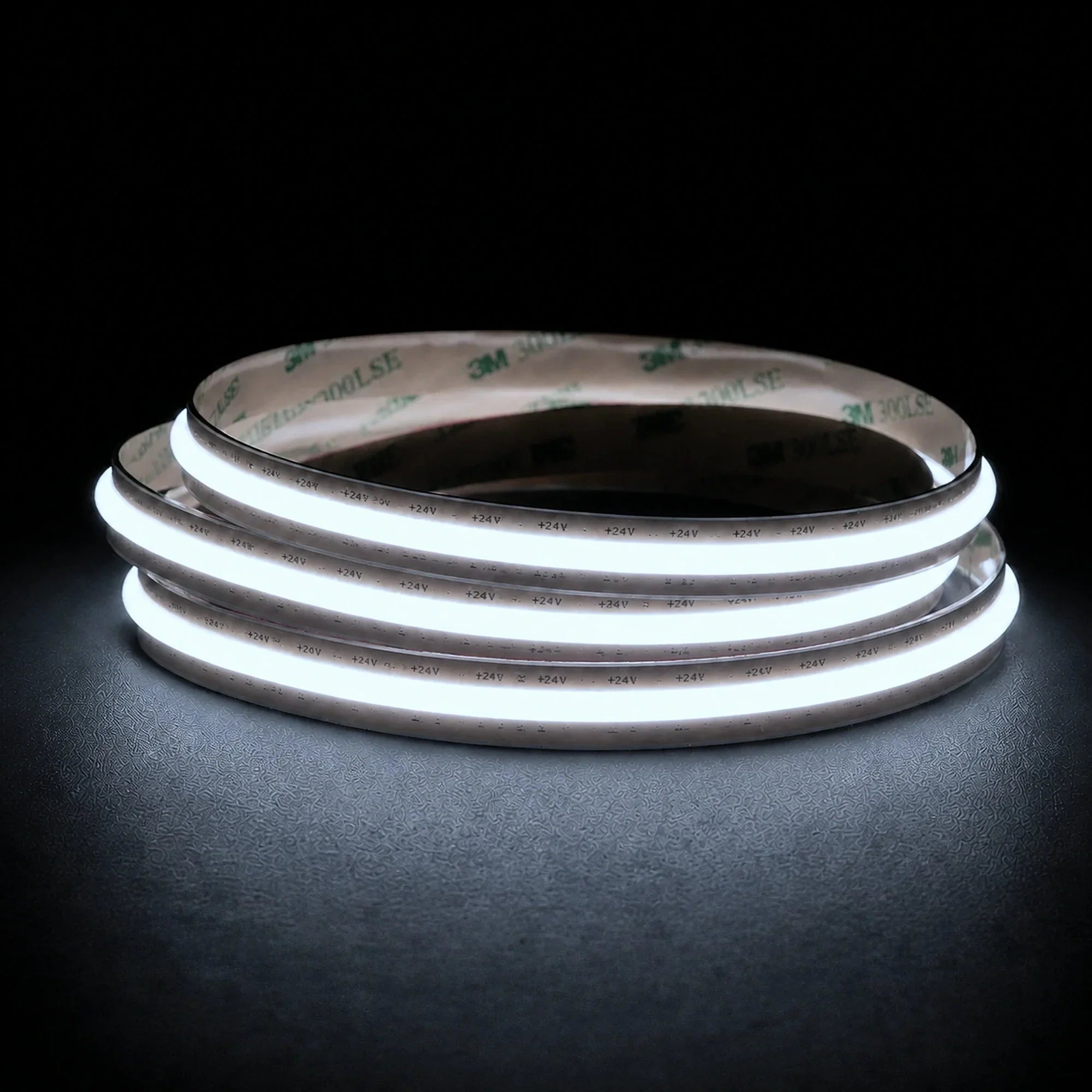 Cool White 6500K Free Cut COB LED strip coil illuminated on a dark background, 24V DC and 10mm wide.