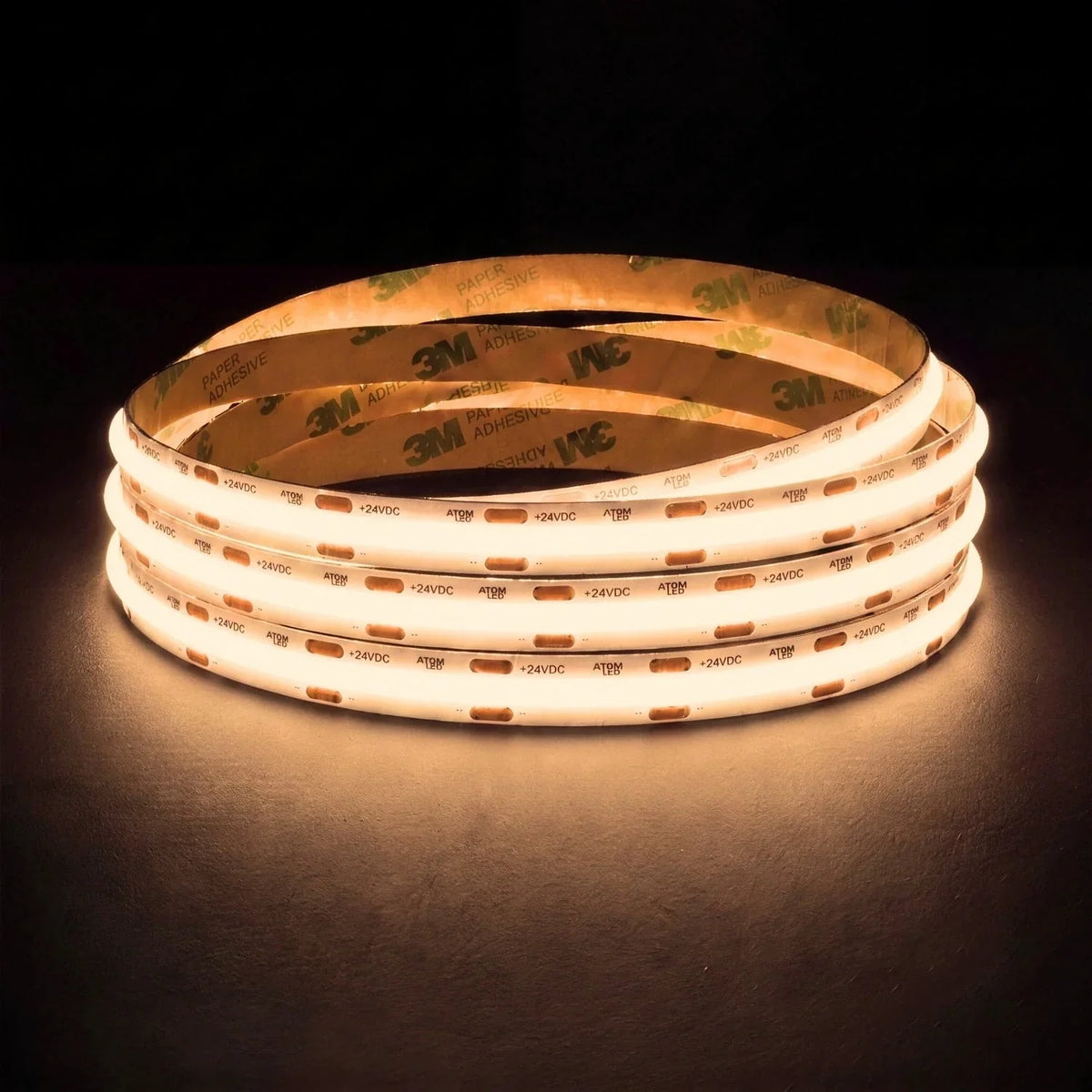 Warm White 3000K SCOB LED strip coil illuminated on a dark background, 24V DC and 10mm wide.