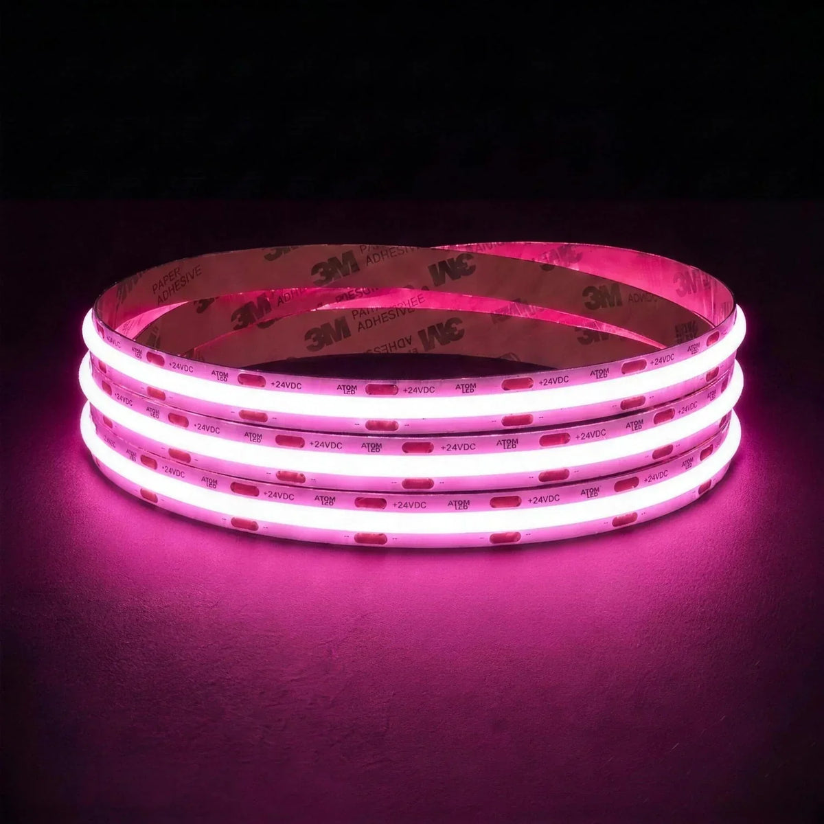 Pink SCOB LED strip coil illuminated on a dark background, 24V DC and 10mm wide.