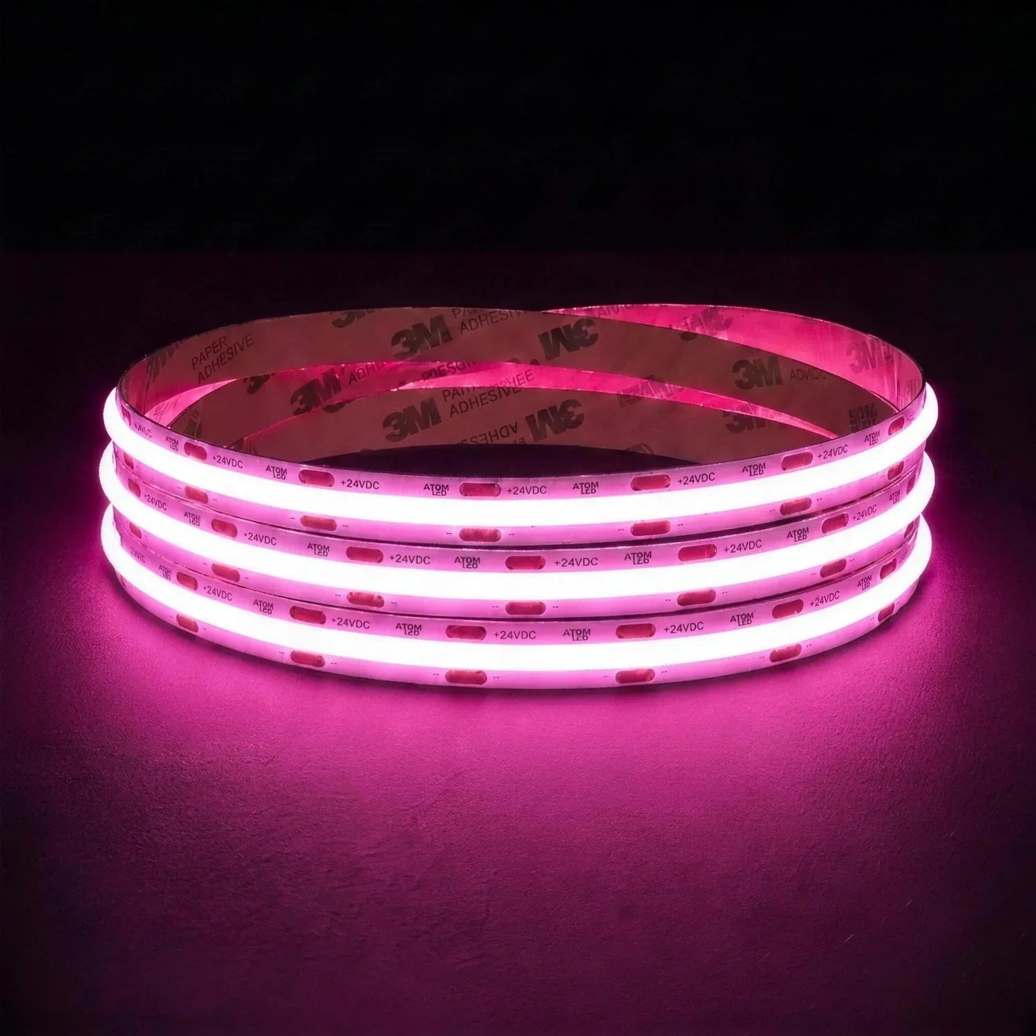 Pink SCOB LED strip coil illuminated on a dark background, 24V DC and 10mm wide.