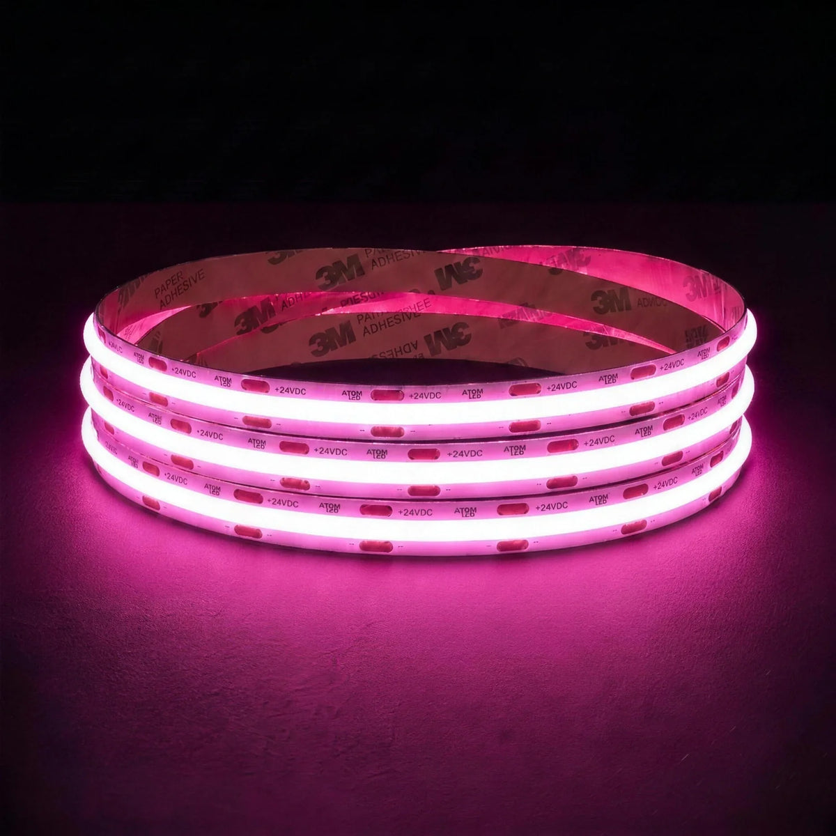 Pink SCOB LED strip coil illuminated on a dark background, 24V DC and 10mm wide, with copper connection pads