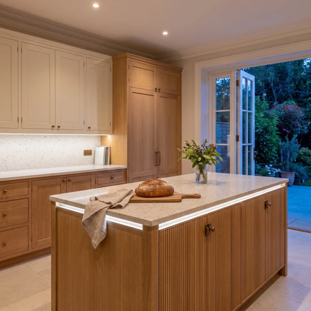 Daylight 5000K 24V 10mm free cut COB LED strip installed beneath cabinets and around a British kitchen island; installation visual.